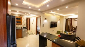 A modern kitchen with a refrigerator, dishwasher, and a dining area with a table and chairs.
