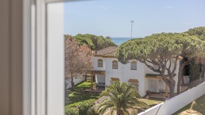 A view of a building with a tiled roof, a garden with a palm tree, and a clear sky. - Apartment 'Los Drogos, Building B, Penthouse B' with shared pool, garden & Wi-Fi (Chiclana de la Frontera)