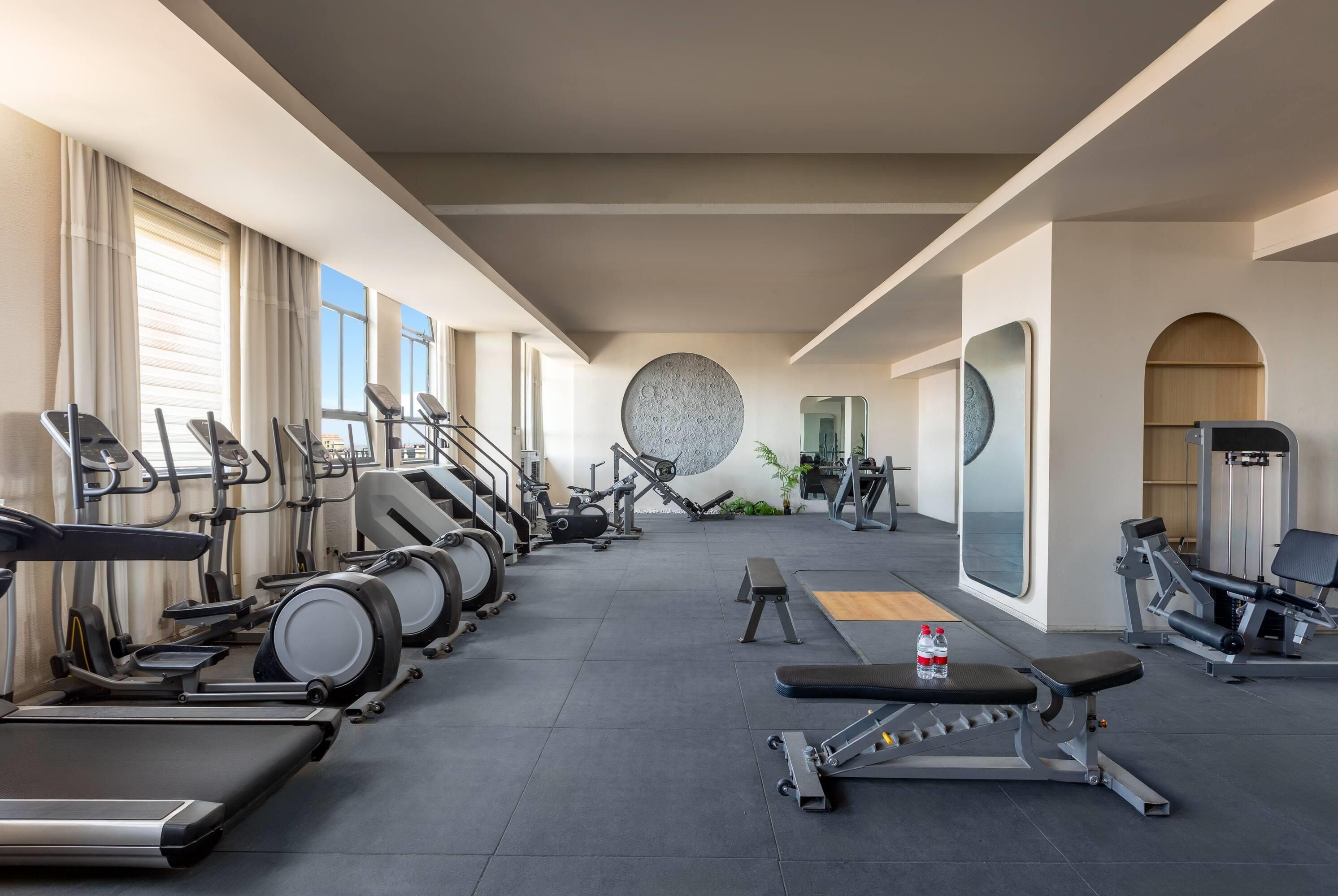 Gimnàs amb cintes de córrer, el·líptiques i equipament de musculació.