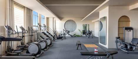 A gym with treadmills, elliptical machines, and weight equipment.
