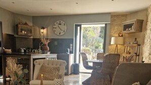 A modern living room with a sofa, coffee table, and a dining area with chairs.