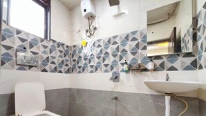 A bathroom with a toilet, sink, and shower.