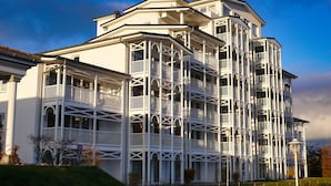 Un edificio de varios pisos con balcones y una fachada simétrica.