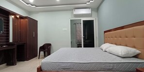 A bedroom with a bed, wardrobe, and a desk.