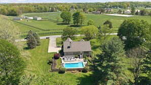 A large house with a swimming pool, surrounded by a fenced yard and trees. - Loveland Luxury Getaway | Pool | Golf Course (Loveland)