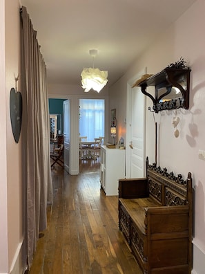 Un plancher en bois, un banc, un miroir fixé au mur et un luminaire suspendu au plafond.