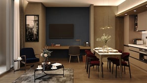 A modern living room with a dining area, a large flat-screen TV, and a kitchen with a built-in oven. - Radisson Blu Residence Istanbul Kartal (Istanbul)