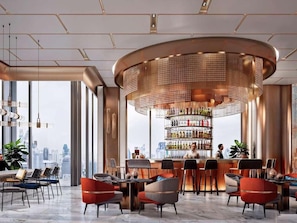 Eine moderne Bar mit kreisender Kronleuchter, Blick auf die Stadt und verschiedenen Sitzmöglichkeiten.