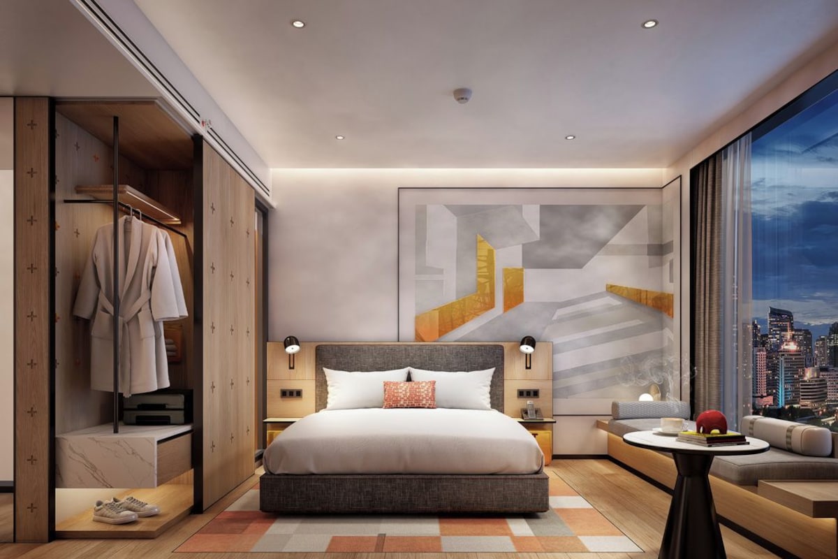 Ein modernes Hotelzimmer mit einem großen Bett, einer Sitzecke und Blick auf die Stadt.