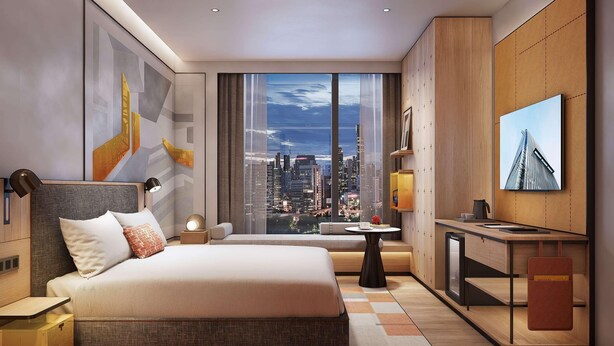 A modern hotel room with a large bed, a desk, and a city view.