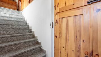 A staircase with granite steps leading to a wooden door with a metal handle.