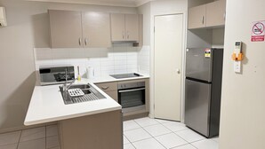 Uma cozinha equipada com micro-ondas, fogão, pia e geladeira.