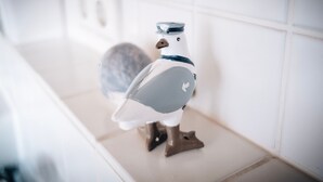 Una figurita de pájaro de cerámica sobre una encimera de cocina.