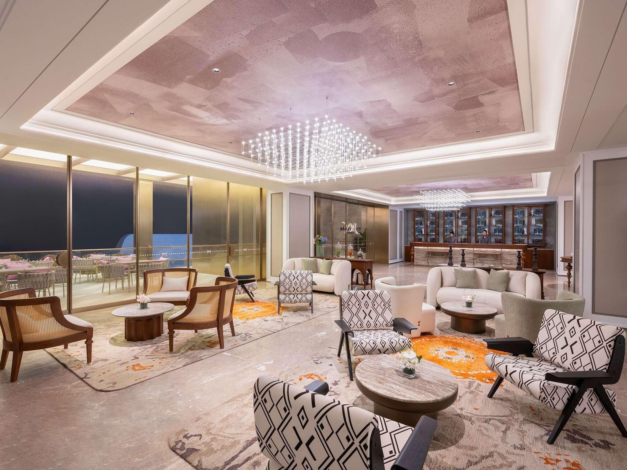 A spacious lounge area with seating, a bar, and a view of the city.