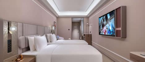 A modern hotel room with a large bed, a flat-screen TV, and a bedside table.