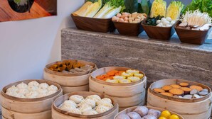 A variety of food items in bamboo steamers, including dumplings and vegetables. - Mercure Beijing Lize Road (Beijing)