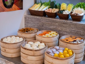 A variety of food items in bamboo steamers, including dumplings and vegetables. - Mercure Beijing Lize Road (Beijing)