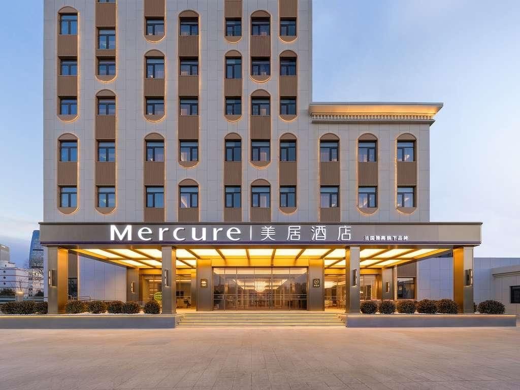 Ein Hotel mit moderner Fassade, mehreren Etagen und einem überdachten Eingangsbereich.
