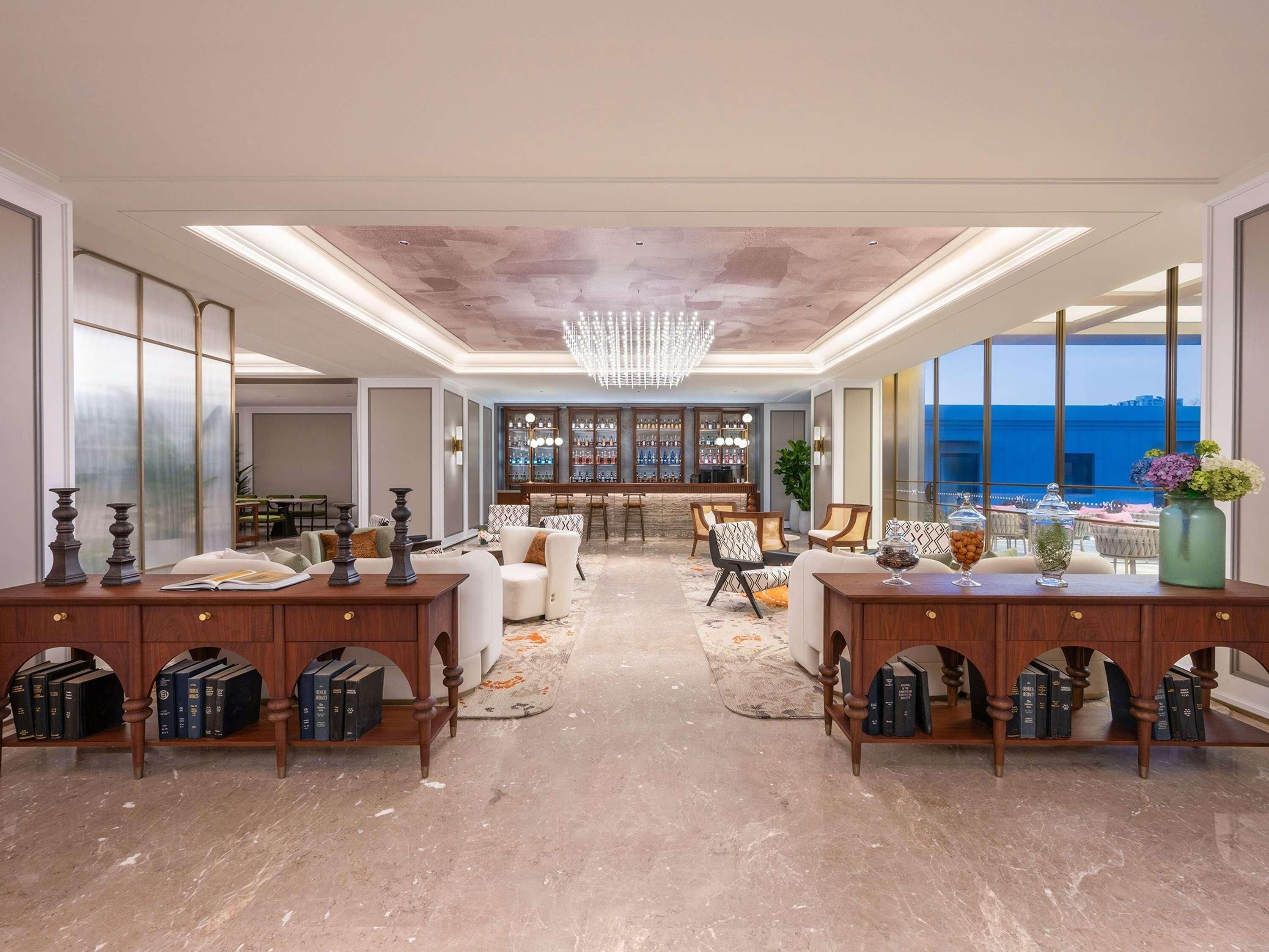 A spacious room with a bar area, seating, and a view of the sea.