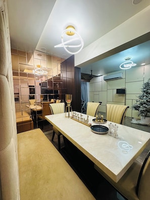Uma área de refeições moderna com uma mesa de mármore, cadeiras de couro e objetos decorativos.
