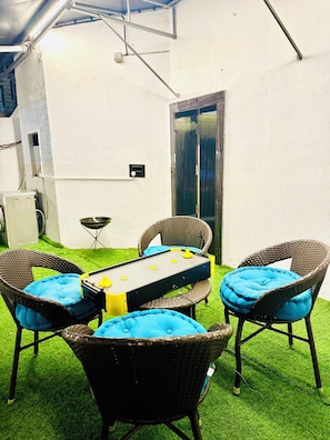 An outdoor patio with a table, chairs, and a small heater.