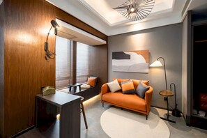 Ein modernes Wohnzimmer mit einer Couch, einem Schreibtisch und einer Lampe.