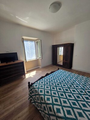 A room with a bed, a dresser, a mirror, and a window. - Oasis of Peace: three-room apartment with private garden a few steps from the sea (Fregene)