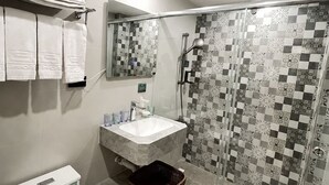 A bathroom with a toilet, sink, and shower area. - Tongcheng Fudelai Grand Hotel (Tainan)