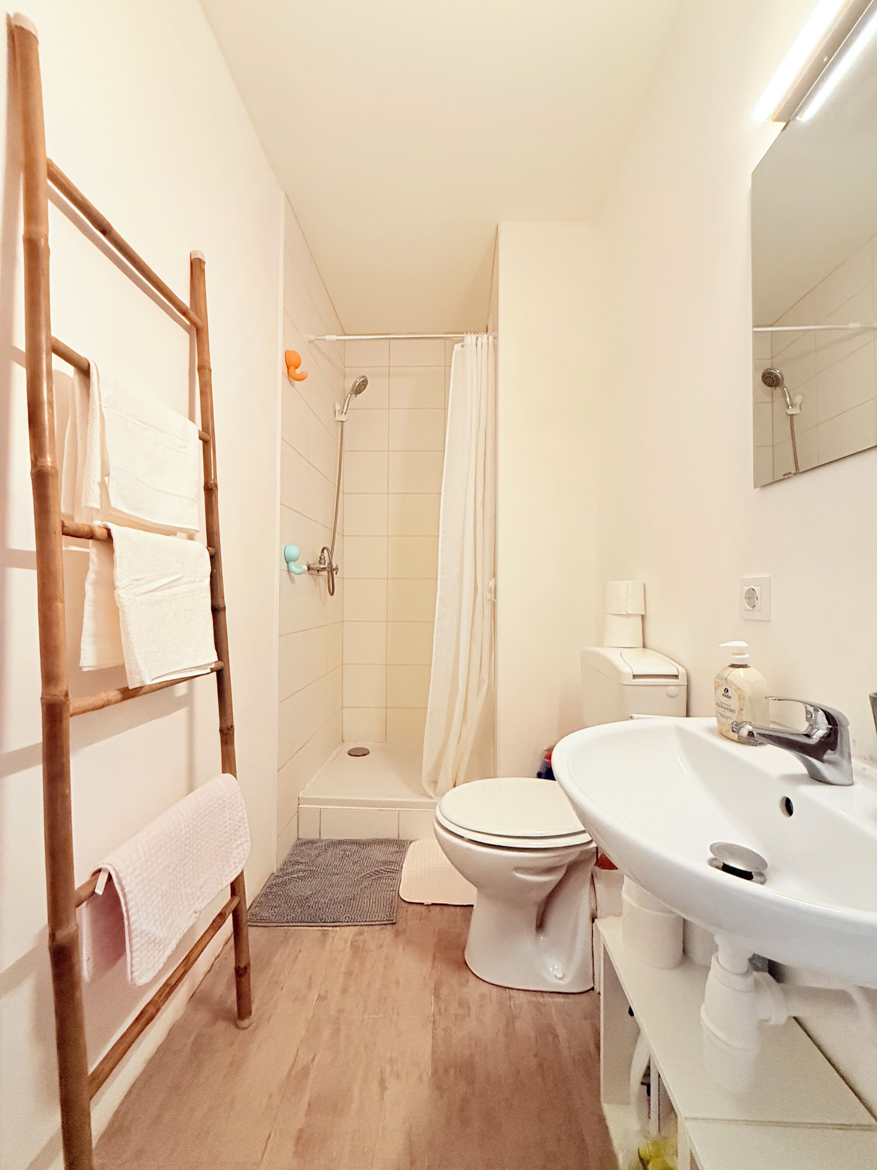 A bathroom with a shower, toilet, and sink.