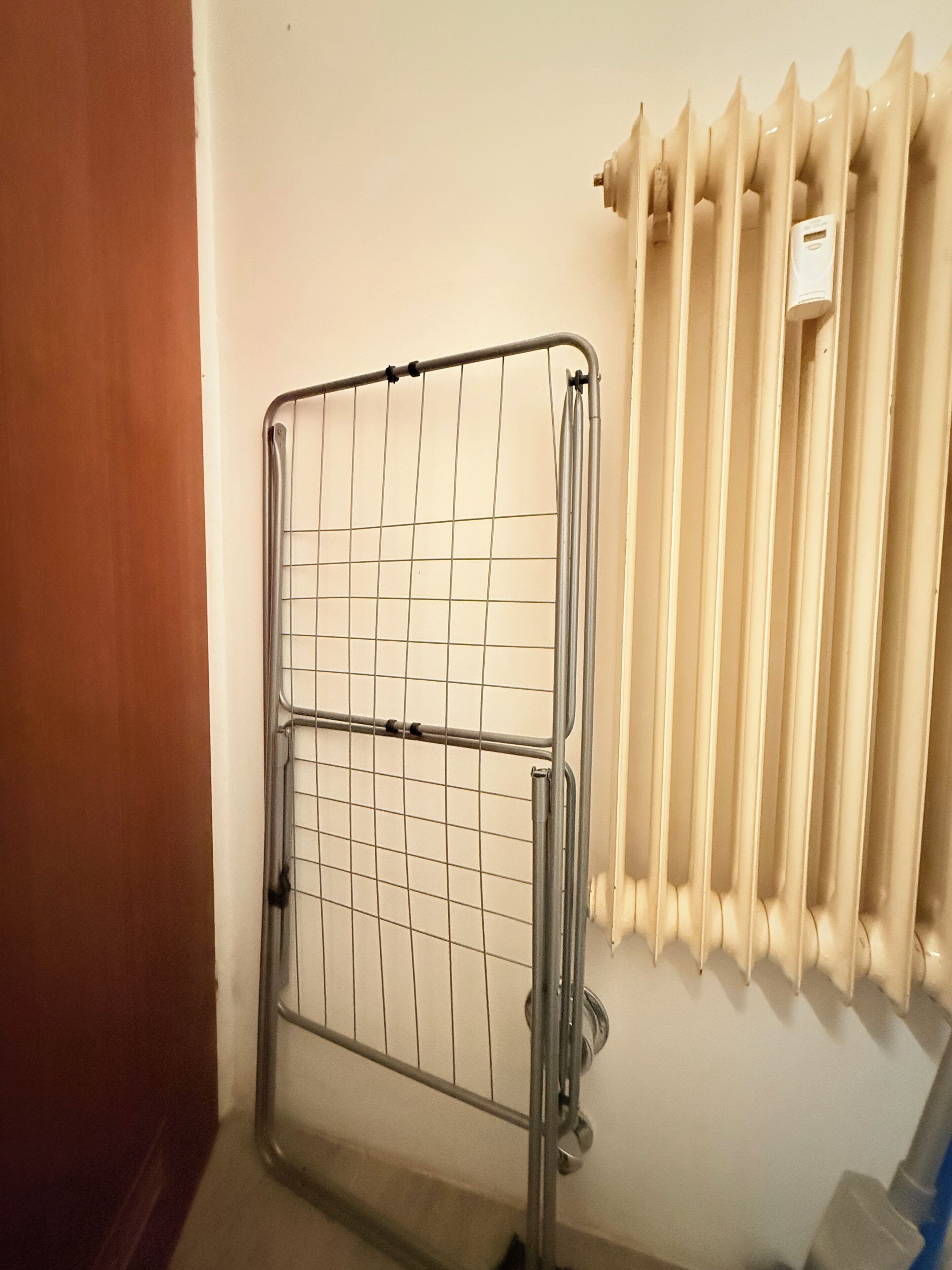 Una reja metálica en un pasillo con un radiador en la pared.