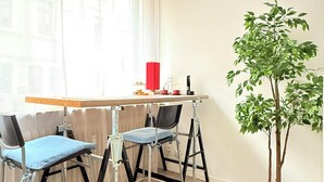 A room with a desk, two chairs, a potted plant, and a window with curtains. - 2 bedrooms - baby crib & furnished  (Luxembourg City)