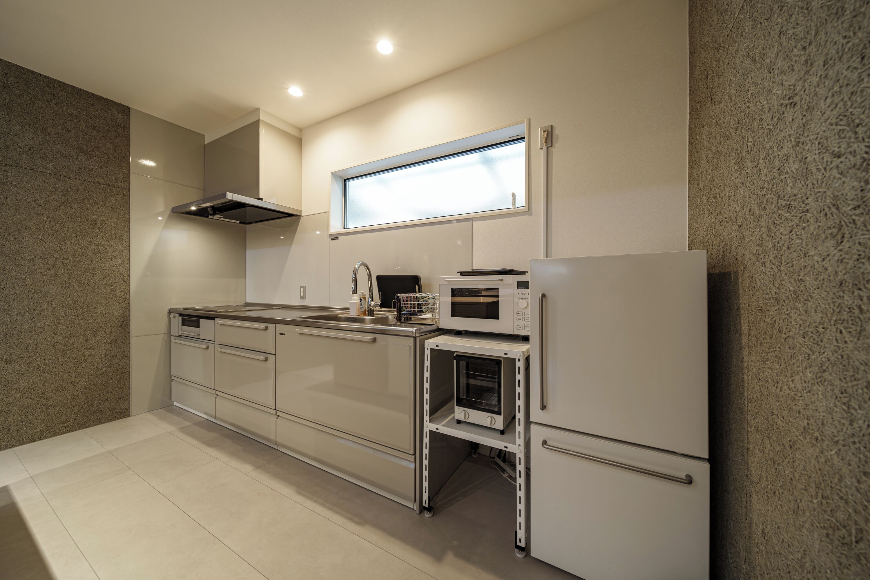 A modern kitchen with a built-in oven, microwave, and stainless steel appliances.