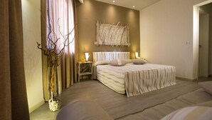 A bedroom with a bed, bedside lamps, a wall-mounted artwork, and a vase with branches. - Hotel Tirreno (Pizzolungo)