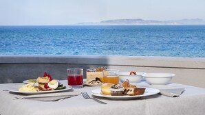 A table with breakfast items and a glass of orange juice, overlooking the sea. - Hotel Tirreno (Pizzolungo)