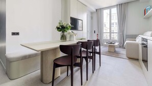 Een moderne keuken met een eethoek, een ingebouwde televisie en uitzicht op de stad.