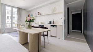 Een moderne keuken met een eethoek, een inbouwoven en een koffieapparaat.