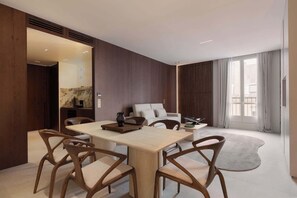 A modern hotel room with a dining area, a sofa, and a large window. - A Splendid 2-BR/2Ba w/ Services - Champs Elysées (Paris)