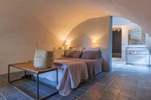 Une chambre à coucher avec un lit, des lampes de chevet, une table de chevet en bois et un panier en osier.