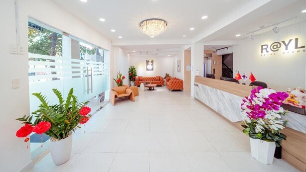 A hotel reception area with a modern design, featuring a reception desk, seating area, and a chandelier. - Royal Crown Hotel (Ho Chi Minh City)