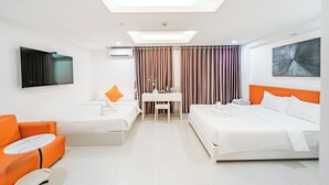 A hotel room with two beds, a desk, a TV, and a seating area. - Royal Crown Hotel (Ho Chi Minh City)