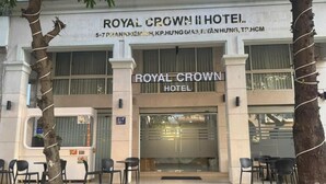 The exterior of the Royal Crown Hotel with a two-story facade, a glass entrance, and outdoor seating area. - Royal Crown Hotel (Ho Chi Minh City)
