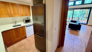 Una cocina moderna con armarios de madera, un refrigerador de acero inoxidable, un microondas y un lavavajillas.
