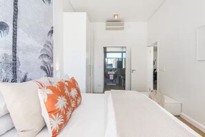 A hotel room with a bed, a wardrobe, a mirror, and a bathroom visible through an open door. - Signature Home @ Waterfront Canals (Cape Town)