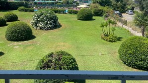 Ein gepflegter Garten mit ordentlich geschnittenen Büschen und freiem Blick auf das Meer.