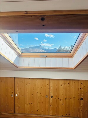 A room with a skylight, wooden walls, and a view of a mountain. - Apartment spirit house Ciboure (Urrugne)