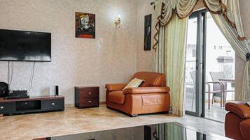 Apartamento Deluxe, balcón, vistas a la ciudad | Zona de estar | Smart TV de 75 pulgadas con canales por satélite, películas de estreno