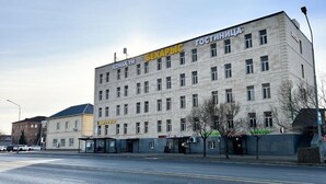 Un edificio de varios pisos con señalización que indica 'БЕКАРВИС' y 'GOSTINNIЦA', mostrando que es un hotel.