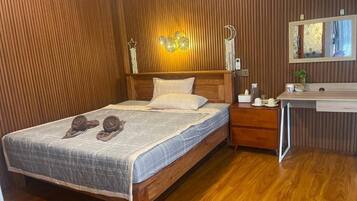 Una habitación con paneles de madera, una cama, una mesita de noche y un espejo.