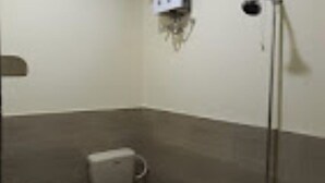 A bathroom with a toilet, a bidet, and a hand dryer.