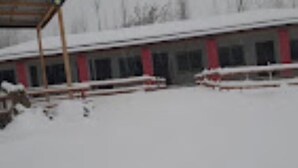 A building with a series of windows and a covered area.